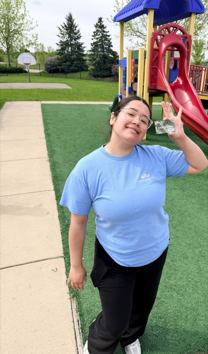 A teacher on the playground showing off her award